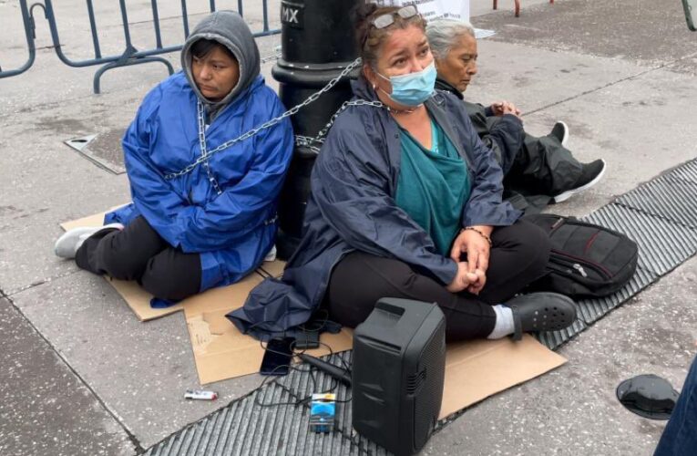 Mujeres se encadenan a poste frente a Palacio Nacional.